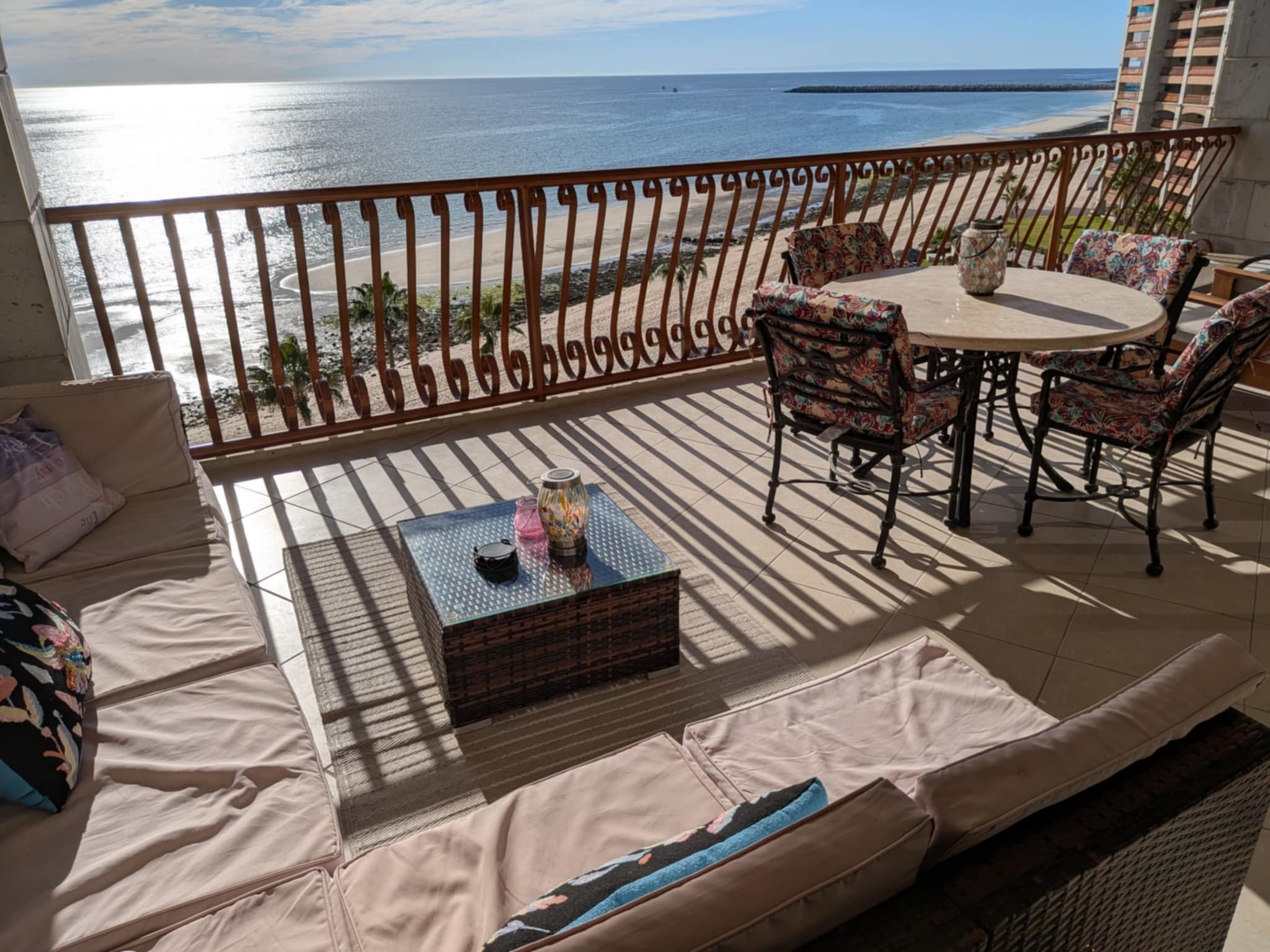 Furnished balcony with dining table and lounge seating overlooking the ocean