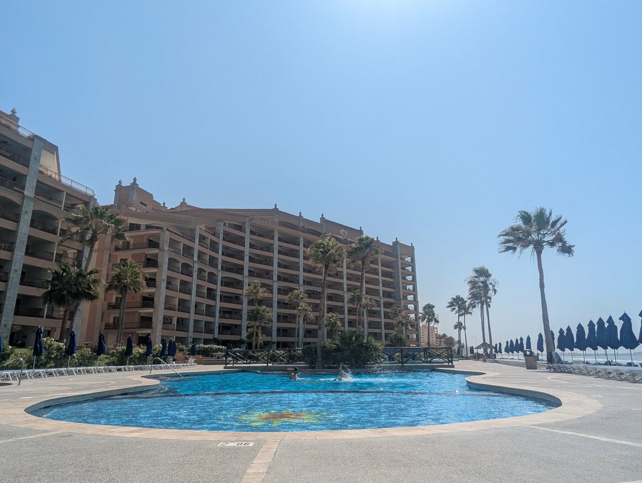 Sonoran Sun resort towers rising behind the main pool and palm trees